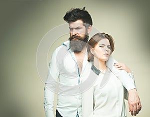 Barbershop concept. Fashion shot of couple after haircut. Woman on mysterious face with bearded man, light background