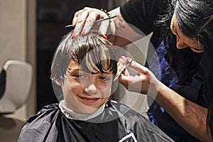 barbershop cuts the ends of wet clean hair to a boy
