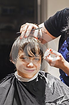 barbershop cuts the ends of wet clean hair to a boy