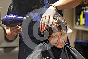 barbershop dries hair of a teenager after a fashionable