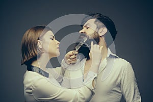 Barbershop or hairdresser concept. Woman hairdresser cuts beard with scissors. Man with long beard, mustache and stylish