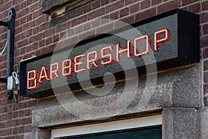 Barbershop neon sign on a brick wall