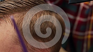 Barbershop: woman barber blow-dries a men's hair