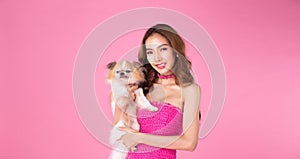 Barbie Girl wear chocky Pink dress hold cute dog and look at camera over pink background
