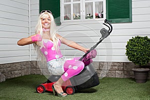 Barbie sitting on a lawn-mower