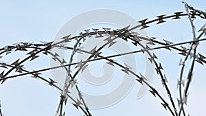 Barbwire security rolls protection over blue sky