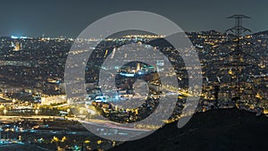 Barcelona and Badalona skyline with roofs of houses and sea on the horizon night timelapse