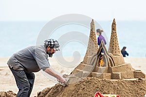 Sand sculptor working at La Barceloneta Beach in Barcelona Spain