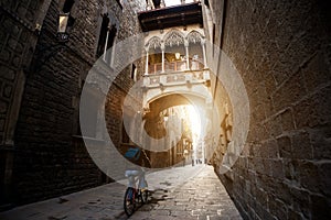 Barcelona people biking bicycle in Barri Gothic Quarter and Bridge of Sighs in Barcelona, Catalonia, Spain.. photo