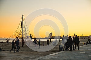 Barcelona, Spain - 05.12.2018: Beautiful sunset on the Barceloneta Beach near a Rope Playground Equipment for Kids