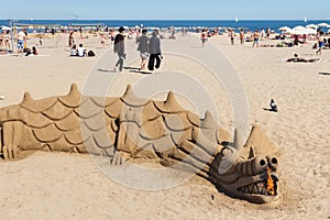 BARCELONA, SPAIN - MAY 15, 2017: Sand sculpture in the shape of a dragon on the beach in Barcelona