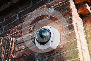 Axis 360 degrees surveillance camera on brick wall