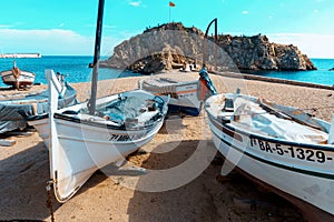 Barcelona, Spain-October 12, 2022. Costa Brava beach, fishing boats and Sa Palomera rock in the village of Blanes, Spain
