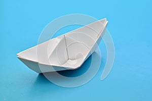 Barco de papel sobre fondo azul