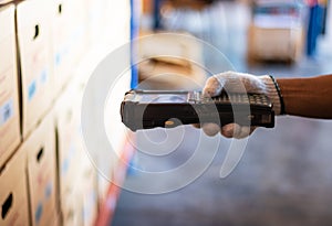 Barcode scanner staff wearing white gloves. Holding a barcode reader. The product has a sticker using modern technology to read