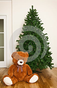 Bare artificial christmas tree with teddy bear