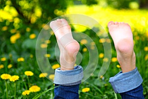 Bare boy feet on the summer green grass