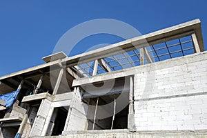 Bare brick block wall and concrete pillar structure of home under construction