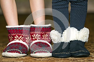 Bare child legs and feet in red winter christmas boots with ornament pattern