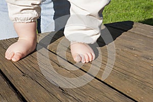 Bare feet of a baby doing his first steps