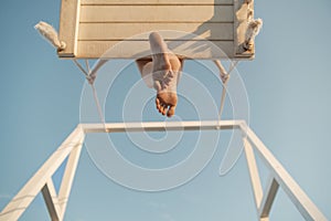 Bare feet bottom view. Girl on rope swing on sky background. Woman og child sitting on swing