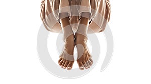 Bare feet crossed at the ankles, with a draped brown fabric, on a white background