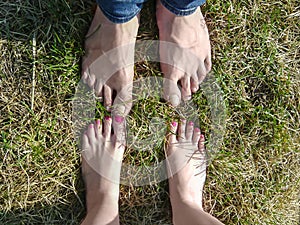 Bare feet of loving couple standing close to each other