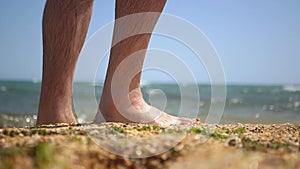 Bare feet of a man walking along the sand near the sea, close-up. HD, 1920x1080. slow motion.