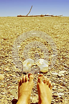 Bare feet in a shingle beach