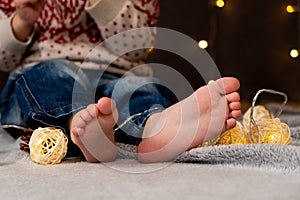 Bare feet of a small child. Cozy Christmas mood.