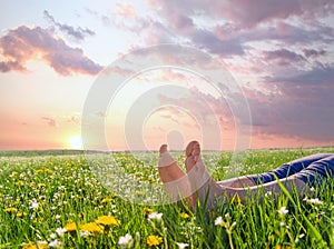 Bare feet on spring grass and flowers