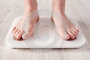 Bare feet stand on smart scales that makes bioelectric impedance analysis, BIA, body fat measurement.