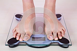 Bare feet standing on a weight scales