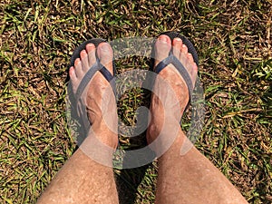 Bare feet stepping on the grass and dirt floor