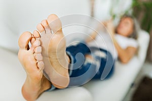 Bare feet of woman in jeans using smart phone.bare foot