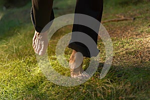 Bare feet of a woman walking carefully on soft moss