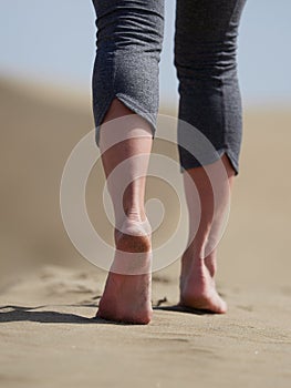 Bare feet of young woman jogging/walking on the beach