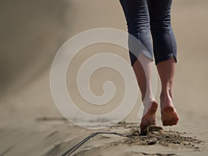 Bare feet of young woman jogging/walking on the beach