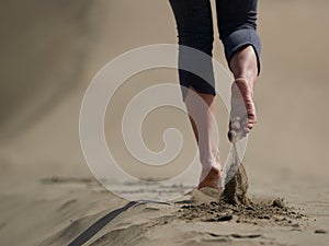 Bare feet of young woman jogging/walking on the beach