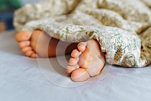 Bare feet young woman under blanket