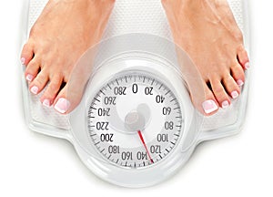 Bare female feet standing on bathroom scale