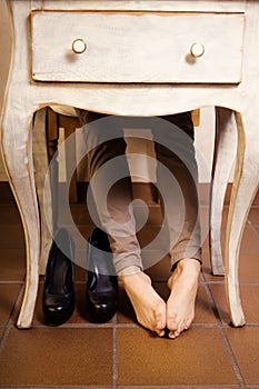 Bare female feet under the vintage table.