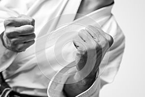 Bare fists of a man dressed for martial arts