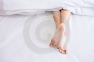 Woman foot on the bed.