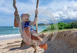 Bare Foot Girl Swings on a Rope Swing by the Beach