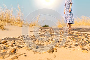 Bare foot unhappy woman walk on the rock sand road alone