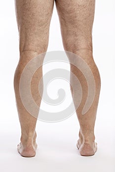 Bare hairy male legs on a white background. Close-up