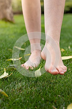 Bare legs and feet with goosebumps walking on the grass to connect with nature