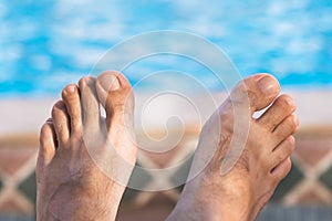 Bare male feet by the poolside