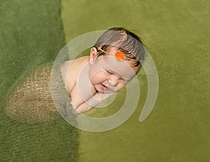 Bare newborn baby with headband